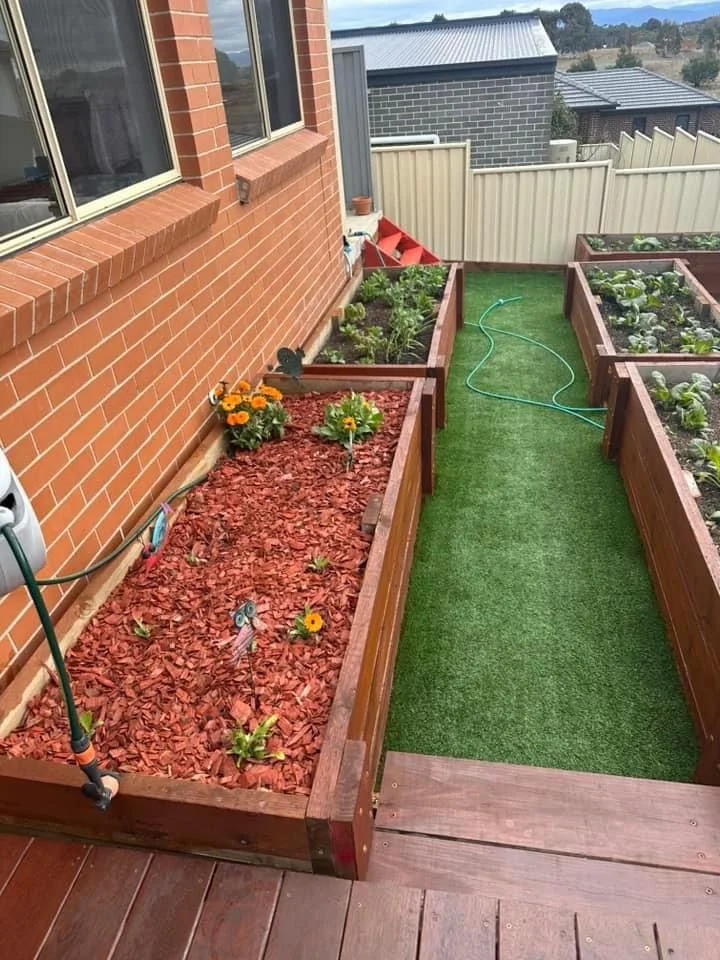 Well-maintained front yard with manicured lawn and garden beds